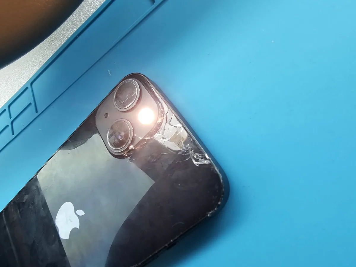 Before back glass replacement: cracked iPhone rear glass around the two camera lenses